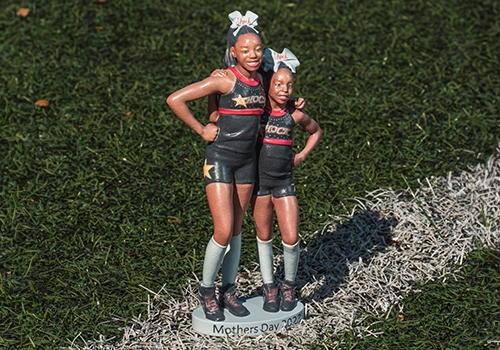 3D-printed figurines of two cheerleaders on a custom Mother's Day base